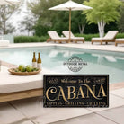 Welcome to the Cabana personalized wall sign by Toe Fish Art in vintage black with rustic gold lettering, available in framed canvas or waterproof outdoor metal, with custom family name and established year, and fun sayings like Relax & Unwind, Sipping-Grilling-Chilling—charming pool, spa, beach, lake, or patio decor handmade in the USA. Ideal for enhancing your outdoor summer decor. Built to last with genuine craftsmanship, this authentic sign adds classic cottage charm and heritage quality to any space.