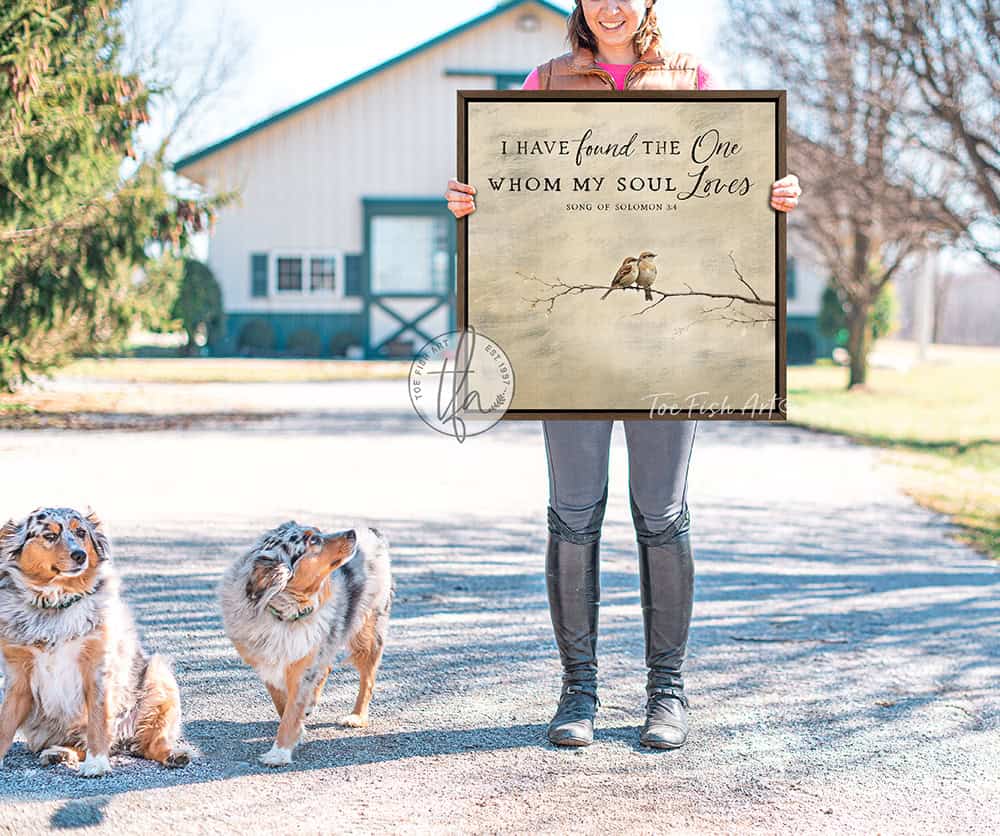 This faith-based wall decor brings the message "I Have Found the One Whom My Soul Loves" to your home through a quaint depiction of two love birds sharing a quiet moment in this square-shaped wall art. The painting conveys a sense of peace, calm, and connection. Choose between premium framed canvas or durable outdoor metal. Toe Fish Art makes artisan wall art with American materials. Proudly Made in the USA, each piece is expertly constructed with genuine craftsmanship, heritage quality, and rustic charm.