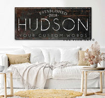 Personalized Family Name Sign with First and Last Names, Established Date, and Custom Wording Options, handmade by Toe Fish Art. Be surrounded by decor you LOVE! Choose between premium framed canvas or durable outdoor metal. Toe Fish Art makes artisan wall art with American materials. Proudly Made in the USA, each piece is expertly constructed with genuine craftsmanship, heritage quality, and rustic charm.
