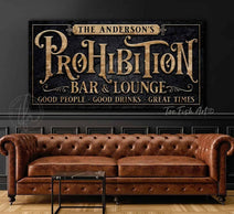 Every great bar deserves a name, and yours deserves a sign to match! This Personalized Prohibition Bar & Lounge Sign in vintage black with woodgrain or rustic gold lettering instantly transforms any space with 1920s industrial appeal. Be surrounded by decor you LOVE! Choose premium framed canvas or durable outdoor metal. Toe Fish Art makes artisan wall art with American materials. Proudly Made in the USA, each piece is expertly constructed with genuine craftsmanship, heritage quality, and rustic charm.