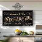 Welcome to the Patio Bar & Grill custom wall sign by Toe Fish Art, handmade in the USA in waterproof outdoor metal or framed canvas, vintage black with rustic gold, personalized family name text, and fun sayings like Kick Back-Stay Awhile, Sipping-Grilling-Chilling. Charming outdoor kitchen, bar, lounge, patio, lanai, deck, porch, or pool decor. Ideal for upgrading your outdoor summer vibe. Built to last with genuine craftsmanship, this authentic sign adds classic charm and heritage quality to any space.
