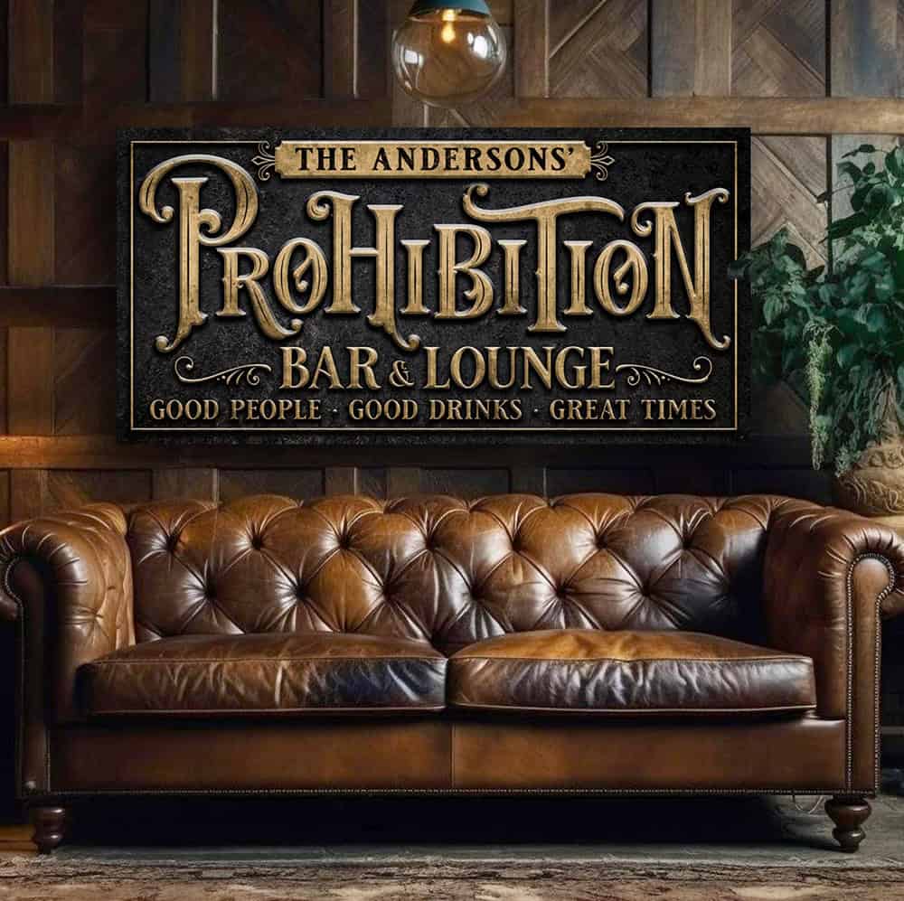 Every great bar deserves a name, and yours deserves a sign to match! This Personalized Prohibition Bar & Lounge Sign in vintage black with woodgrain or rustic gold lettering instantly transforms any space with 1920s industrial appeal. Be surrounded by decor you LOVE! Choose premium framed canvas or durable outdoor metal. Toe Fish Art makes artisan wall art with American materials. Proudly Made in the USA, each piece is expertly constructed with genuine craftsmanship, heritage quality, and rustic charm.