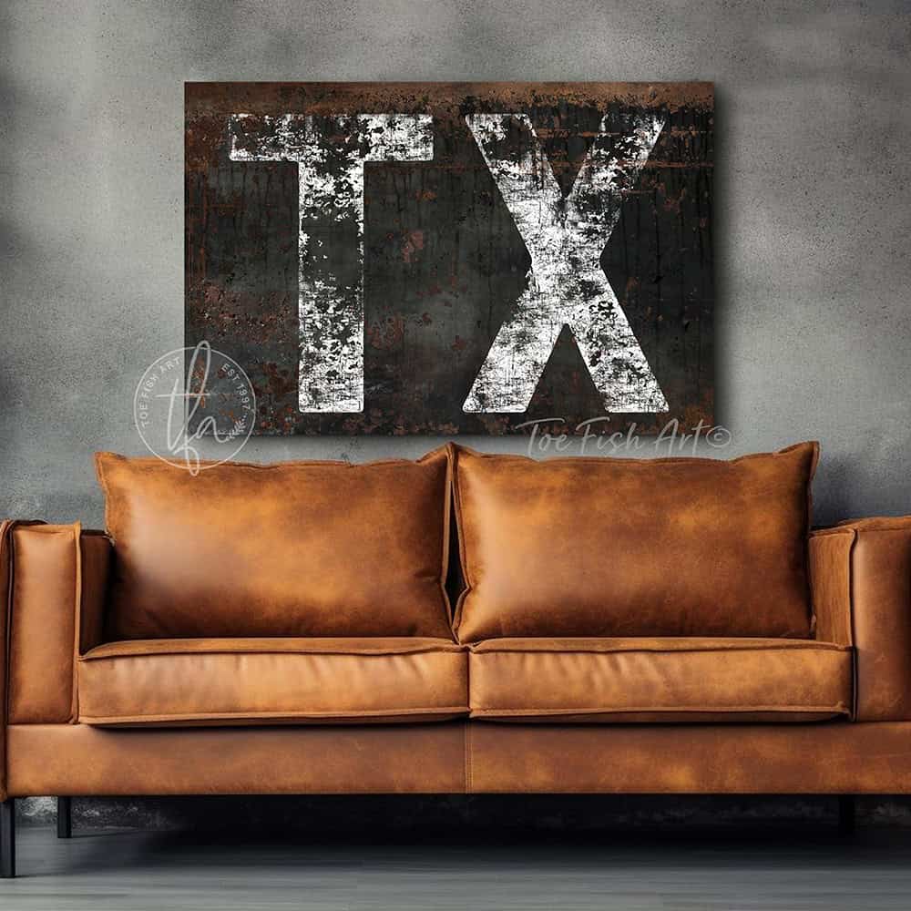 Personalized USA state location wall art featuring your custom two-letter state abbreviation on a dark, distressed industrial farmhouse background with vintage rustic charm and faded white lettering. Be surrounded by decor you LOVE! Choose between premium framed canvas or durable outdoor metal. Toe Fish Art makes artisan wall art with American materials. Proudly Made in the USA, each piece is expertly constructed with genuine craftsmanship, heritage quality, and rustic charm.