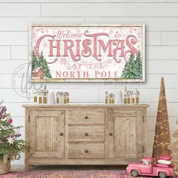 Toe Fish Art Vintage Cottage Welcome to Christmas at the North Pole Pink & Green Holiday Decor Personalized Canvas or Outdoor Metal sign. Rustic Cottage Country Christmas Wall Decor, handmade in the USA from start to finish! Stylish, chic and trendy seasonal winter wall decoration in antique winter white, pink and green. Hand-painted artwork options include Christmas Trees, Gingerbread House, and Snowman designs. Handmade in the USA by ToeFishArt, and built to last a lifetime by the Toe Fish Art family artisans. This beautiful vintage sign adds unique eye-catching decor indoors or outdoors. Great outdoor holiday curb appeal! Cute and clever decor for your outdoor fire pit. Christmas welcome entryway porch or living room fireplace mantel wall hanging or shelf sitter. Original, custom, personalized wall decor signs. Canvas, Wood or Metal. Rustic modern farmhouse, cottagecore, vintage, retro, industrial, Americana, primitive, country, coastal, minimalist. Toe Fish Art and Toefishart.com is a USA small family woman owned business making beautiful decor since 1997.