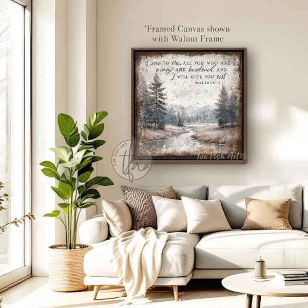 Toe Fish Art presents a vintage serene landscape painting featuring a forested river with a distant mountain range. This unique piece incorporates the Christian scripture from Matthew 11:28: "Come to Me, all who are weary, and I will give you rest." Blending rustic primitive country charm with cottage farmhouse style, this handcrafted artwork is available in durable high-quality framed canvas or outdoor weatherproof solid aluminum metal. Proudly made in the USA, each piece is designed to last a lifetime by the artisans at Toe Fish Art. This beautiful landscape painting enhances any decor, adding eye-catching appeal indoors or outdoors. It’s perfect for display in a porch, entryway, patio, lanai, deck, veranda, living room, fireplace hearth or mantel, dining room, or bedroom, or as a shelf sitter. A stunning reminder of Christian faith and God's love, this artwork fits various styles, including rustic modern farmhouse, cottagecore, vintage, retro, industrial, Americana, primitive, country, coastal, and minimalist. Toe Fish Art is a small family, woman-owned business, creating beautiful decor for almost three decades, since 1997!