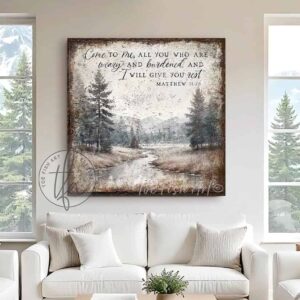 Toe Fish Art presents a vintage serene landscape painting featuring a forested river with a distant mountain range. This unique piece incorporates the Christian scripture from Matthew 11:28: "Come to Me, all who are weary, and I will give you rest." Blending rustic primitive country charm with cottage farmhouse style, this handcrafted artwork is available in durable high-quality framed canvas or outdoor weatherproof solid aluminum metal. Proudly made in the USA, each piece is designed to last a lifetime by the artisans at Toe Fish Art. This beautiful landscape painting enhances any decor, adding eye-catching appeal indoors or outdoors. It’s perfect for display in a porch, entryway, patio, lanai, deck, veranda, living room, fireplace hearth or mantel, dining room, or bedroom, or as a shelf sitter. A stunning reminder of Christian faith and God's love, this artwork fits various styles, including rustic modern farmhouse, cottagecore, vintage, retro, industrial, Americana, primitive, country, coastal, and minimalist. Toe Fish Art is a small family, woman-owned business, creating beautiful decor for almost three decades, since 1997!