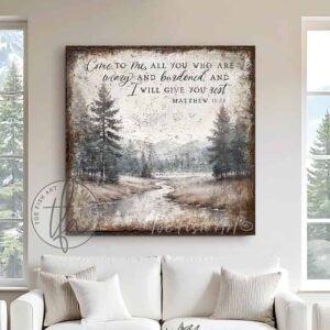 Toe Fish Art presents a vintage serene landscape painting featuring a forested river with a distant mountain range. This unique piece incorporates the Christian scripture from Matthew 11:28: "Come to Me, all who are weary, and I will give you rest." Blending rustic primitive country charm with cottage farmhouse style, this handcrafted artwork is available in durable high-quality framed canvas or outdoor weatherproof solid aluminum metal. Proudly made in the USA, each piece is designed to last a lifetime by the artisans at Toe Fish Art. This beautiful landscape painting enhances any decor, adding eye-catching appeal indoors or outdoors. It’s perfect for display in a porch, entryway, patio, lanai, deck, veranda, living room, fireplace hearth or mantel, dining room, or bedroom, or as a shelf sitter. A stunning reminder of Christian faith and God's love, this artwork fits various styles, including rustic modern farmhouse, cottagecore, vintage, retro, industrial, Americana, primitive, country, coastal, and minimalist. Toe Fish Art is a small family, woman-owned business, creating beautiful decor for almost three decades, since 1997!