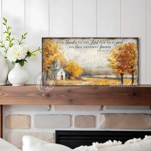 Toe Fish Art's Faith-inspired wall art featuring Psalm 107:1 ‘Give thanks to the Lord for He is good, His love endures forever’ hand-lettered on a rustic country church scene surrounded by golden autumn trees landscape painting. Handmade in the USA and constructed in framed canvas or waterproof outdoor metal. Vintage fall colors, perfect for Christian home décor, Thanksgiving, or seasonal autumn cottagecore decor.