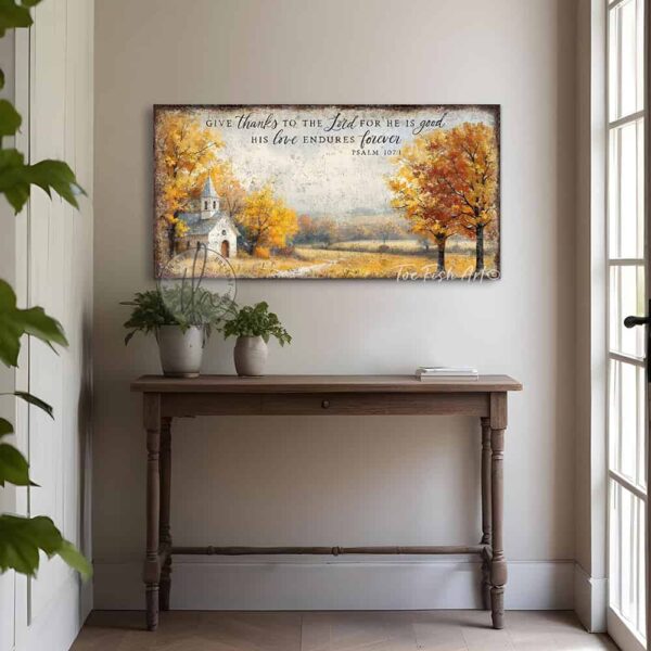 Toe Fish Art's Faith-inspired wall art featuring Psalm 107:1 ‘Give thanks to the Lord for He is good, His love endures forever’ hand-lettered on a rustic country church scene surrounded by golden autumn trees landscape painting. Handmade in the USA and constructed in framed canvas or waterproof outdoor metal. Vintage fall colors, perfect for Christian home décor, Thanksgiving, or seasonal autumn cottagecore decor.