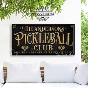Toe Fish Art’s personalized "Pickleball Club” sign features the phrase "Smashin' Dinkin' Sippin' Chillin’" in rustic gold style lettering on a vintage slate black background. Available as a beautiful framed canvas sign or durable and sleek outdoor metal sign, this custom wall art decor adds humor and charm to your game space or post-play lounge area. Made in America and built to last, perfect for pickleball lovers, sports decor, and custom man cave or backyard court accents. This premium printed sign showcases a detailed, original design ideal for upgrading your sports bar, game room, court-side seating, outdoor entertaining space, or backyard decor. Customized sign, personalized with family name or favorite saying and custom wording options. Available in a huge array of sizes, Toe Fish Art's artisan-made wall decor is expertly made in America with American-sourced materials. This high-end, handcrafted piece can be customized to fit your style! Built to last with genuine craftsmanship, this heirloom decor adds rustic cottage charm and heritage quality to any space. Made in the USA with durable, authentic materials for a beautiful and meaningful display to last year after year. Modern Farmhouse Cottagecore wall decor handcrafted in durable high-quality framed canvas or indoor-outdoor weatherproof solid aluminum metal, handmade in the USA from start to finish! Beautiful, stylish and timeless wall decor artwork. Handmade in the USA by ToeFishArt, and built to last a lifetime by the Toe Fish Art family artisans. This beautiful original artwork adds unique eye-catching decor indoors or outdoors. Perfect for your game room, man cave, sports bar post-game lounge, basement bar, garage bar, patio, lanai, deck, or any outdoor living space. This special decoration is a fun way to celebrate your favorite game with friends. Original, custom, personalized wall decor signs. Canvas, Wood or Metal. Rustic modern farmhouse, cottagecore, vintage, retro, industrial, Americana, primitive, country, coastal, minimalist. Toe Fish Art is a USA small family woman owned business making beautiful decor since 1997.
