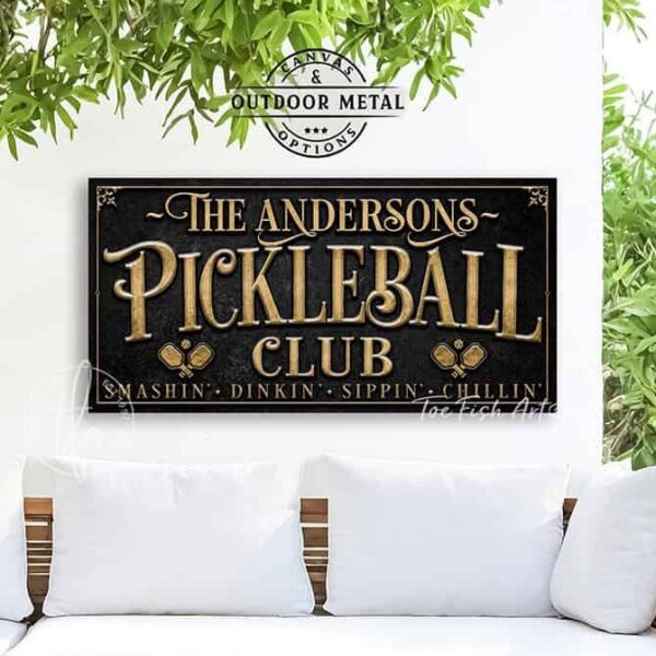 Toe Fish Art’s personalized "Pickleball Club” sign features the phrase "Smashin' Dinkin' Sippin' Chillin’" in rustic gold style lettering on a vintage slate black background. Available as a beautiful framed canvas sign or durable and sleek outdoor metal sign, this custom wall art decor adds humor and charm to your game space or post-play lounge area. Made in America and built to last, perfect for pickleball lovers, sports decor, and custom man cave or backyard court accents. This premium printed sign showcases a detailed, original design ideal for upgrading your sports bar, game room, court-side seating, outdoor entertaining space, or backyard decor. Customized sign, personalized with family name or favorite saying and custom wording options. Available in a huge array of sizes, Toe Fish Art's artisan-made wall decor is expertly made in America with American-sourced materials. This high-end, handcrafted piece can be customized to fit your style! Built to last with genuine craftsmanship, this heirloom decor adds rustic cottage charm and heritage quality to any space. Made in the USA with durable, authentic materials for a beautiful and meaningful display to last year after year. Modern Farmhouse Cottagecore wall decor handcrafted in durable high-quality framed canvas or indoor-outdoor weatherproof solid aluminum metal, handmade in the USA from start to finish! Beautiful, stylish and timeless wall decor artwork. Handmade in the USA by ToeFishArt, and built to last a lifetime by the Toe Fish Art family artisans. This beautiful original artwork adds unique eye-catching decor indoors or outdoors. Perfect for your game room, man cave, sports bar post-game lounge, basement bar, garage bar, patio, lanai, deck, or any outdoor living space. This special decoration is a fun way to celebrate your favorite game with friends. Original, custom, personalized wall decor signs. Canvas, Wood or Metal. Rustic modern farmhouse, cottagecore, vintage, retro, industrial, Americana, primitive, country, coastal, minimalist. Toe Fish Art is a USA small family woman owned business making beautiful decor since 1997.